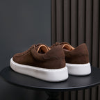Men's dark brown leather sneakers, rear view with lace-up straps and white sole