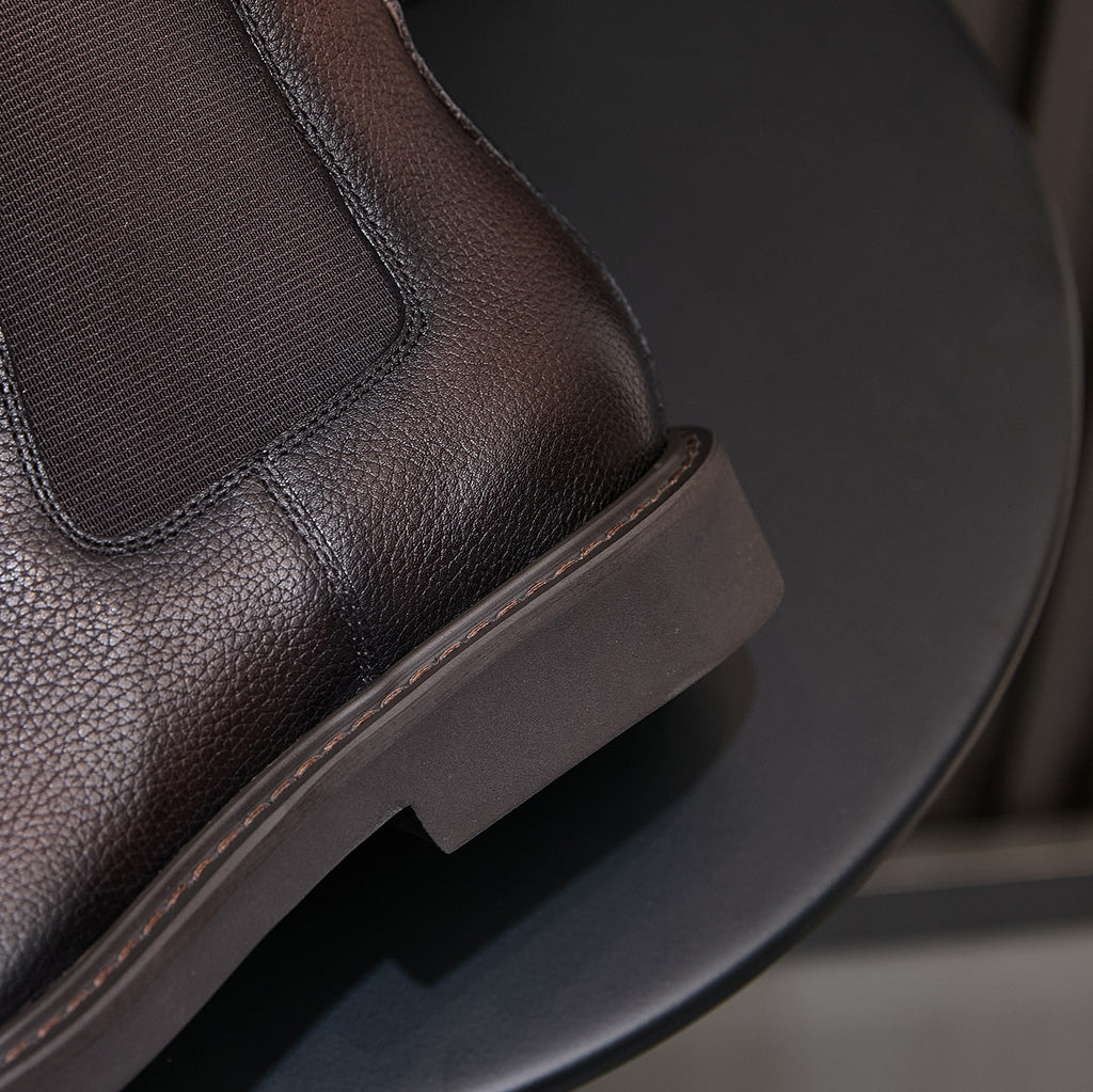 Men's dark brown Chelsea dress boots, close-up of elastic gore and low-profile sole