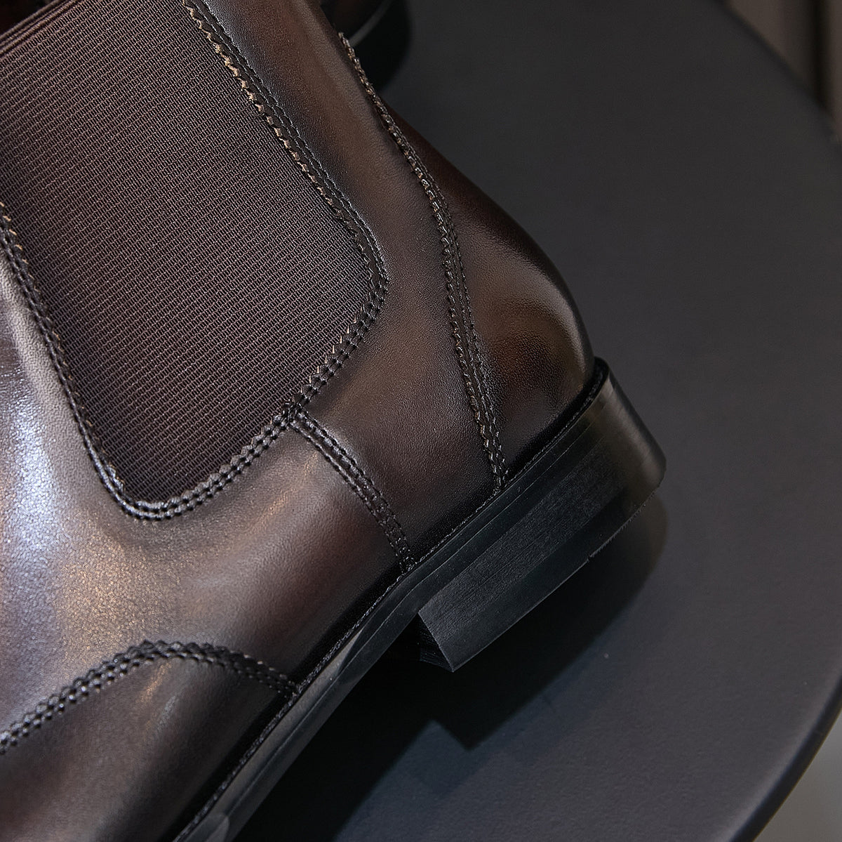 Pointed-toe chelsea boot ankle area with elastic gore and stacked low heel, dark finish