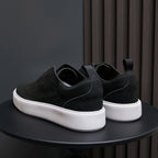 Men's black leather low-top sneakers with slip-on design and thick white sole.