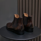 Dark brown suede Chelsea dress boots, back view with elastic gores and block heel sole