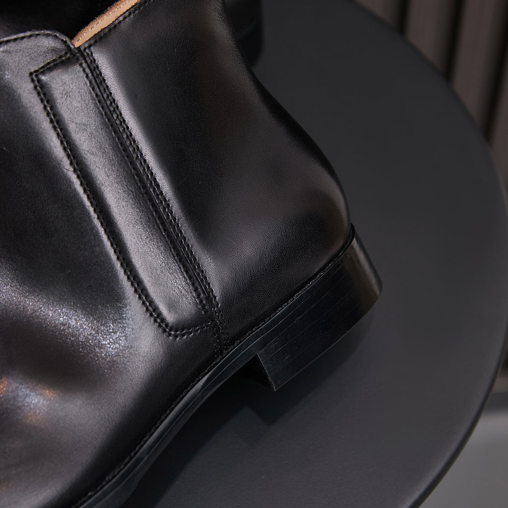 Pointed-toe leather side-zip dress boot in black, close-up of heel and stitching