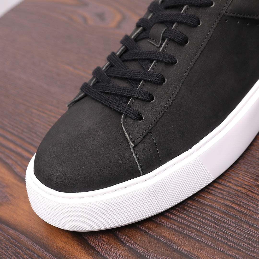 Close-up of black leather sneaker toe and lace-up eyelets with white sole edge