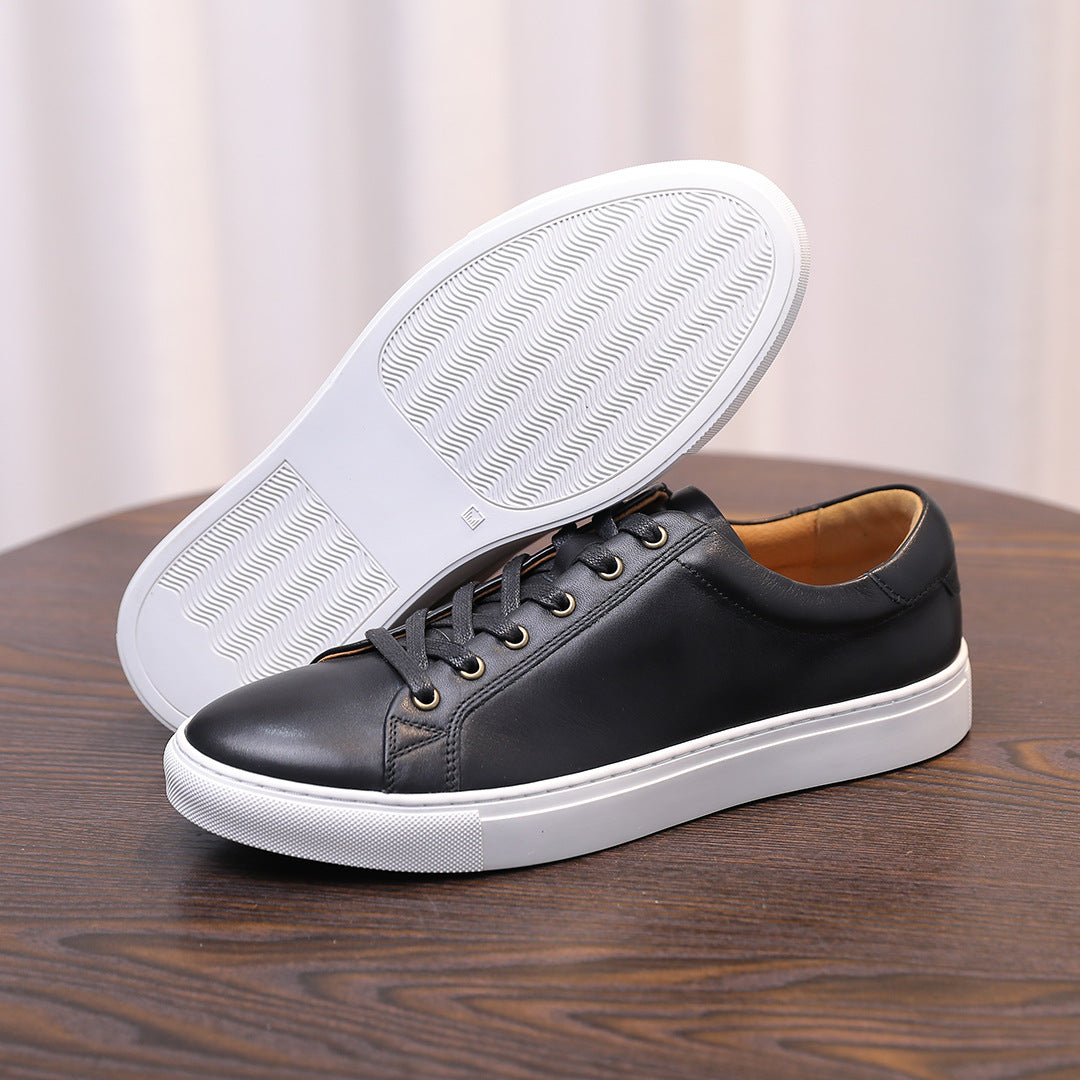 Black leather sneakers with white rubber outsole and textured tread bottom.