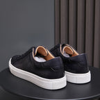 Back view of men’s black leather lace-up sneakers with white rubber heel sole