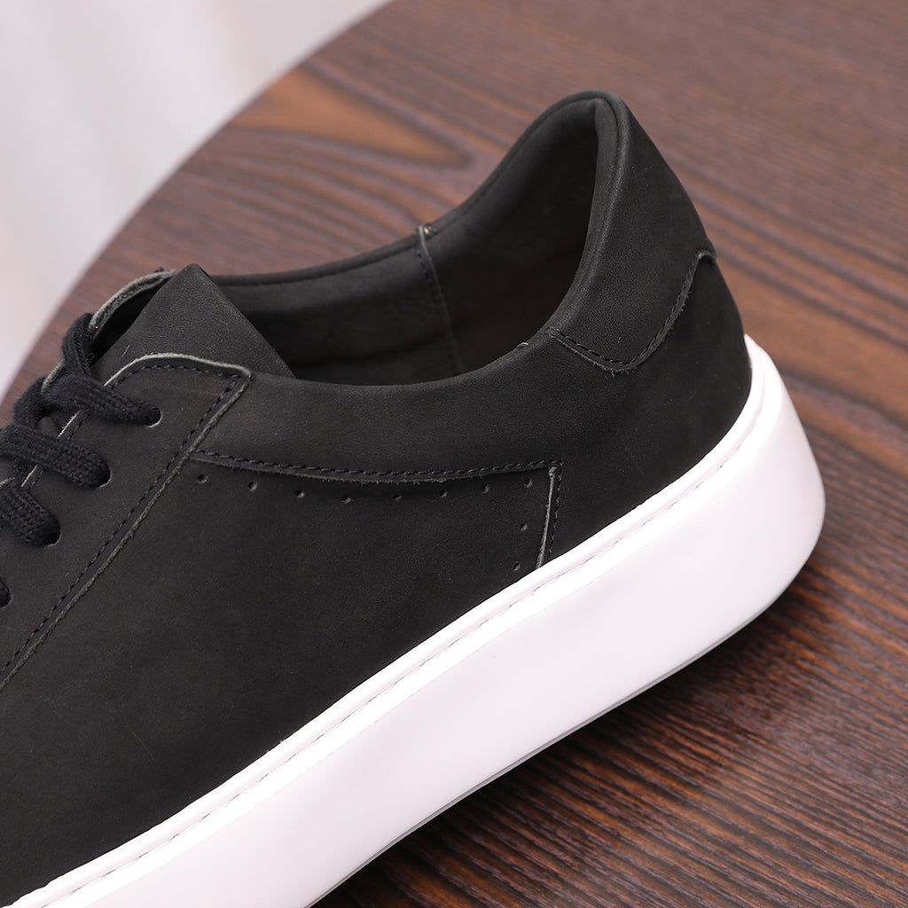 Close-up of black leather sneaker quarter panel and padded collar