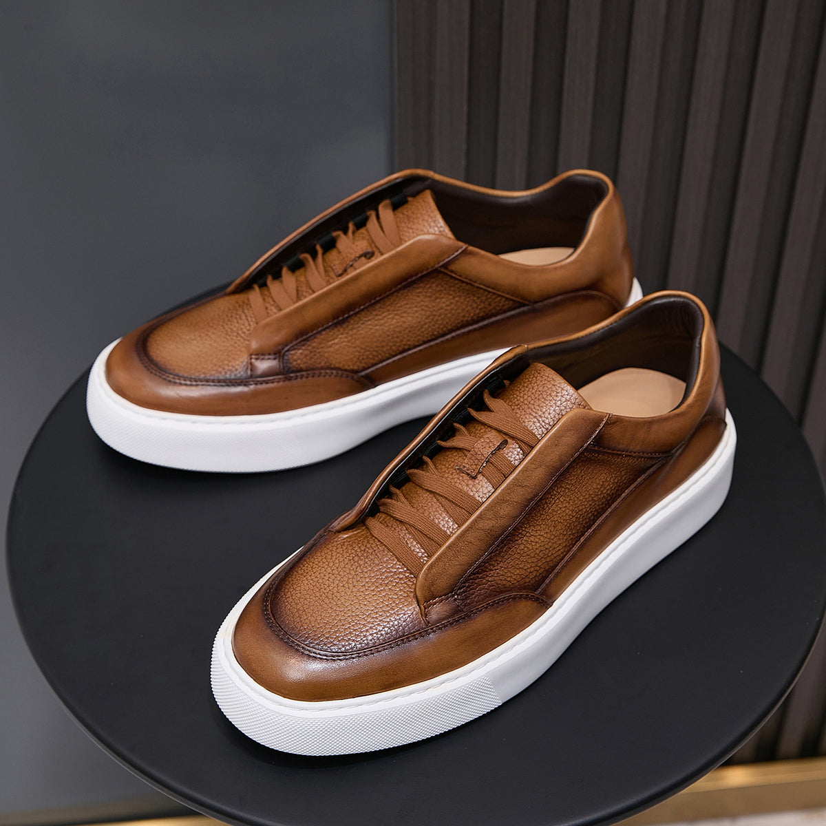 Pair of brown leather sneakers with lace-up front and white platform sole