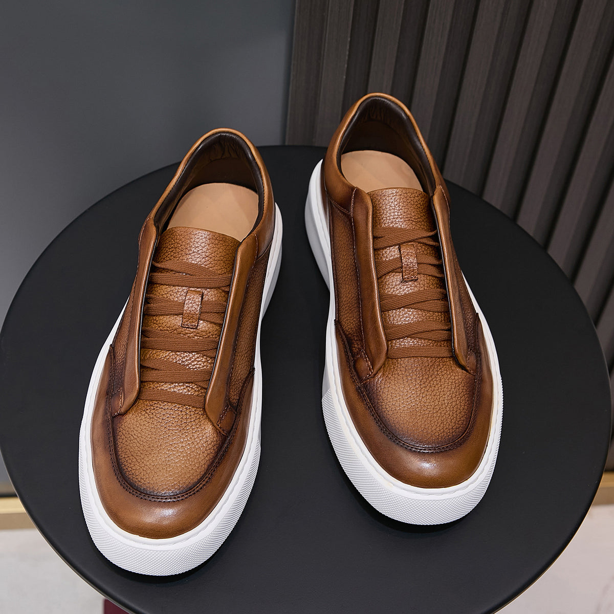 Brown leather sneakers showing interior lining and lace-up tongue