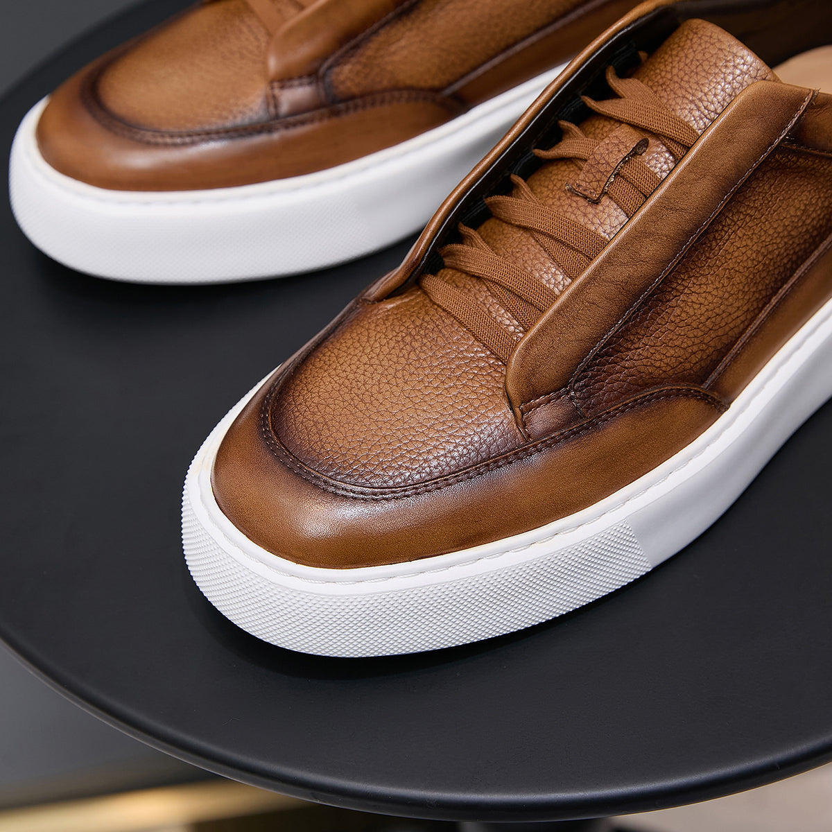 Brown leather sneakers with lace-up detail and thick white rubber sole