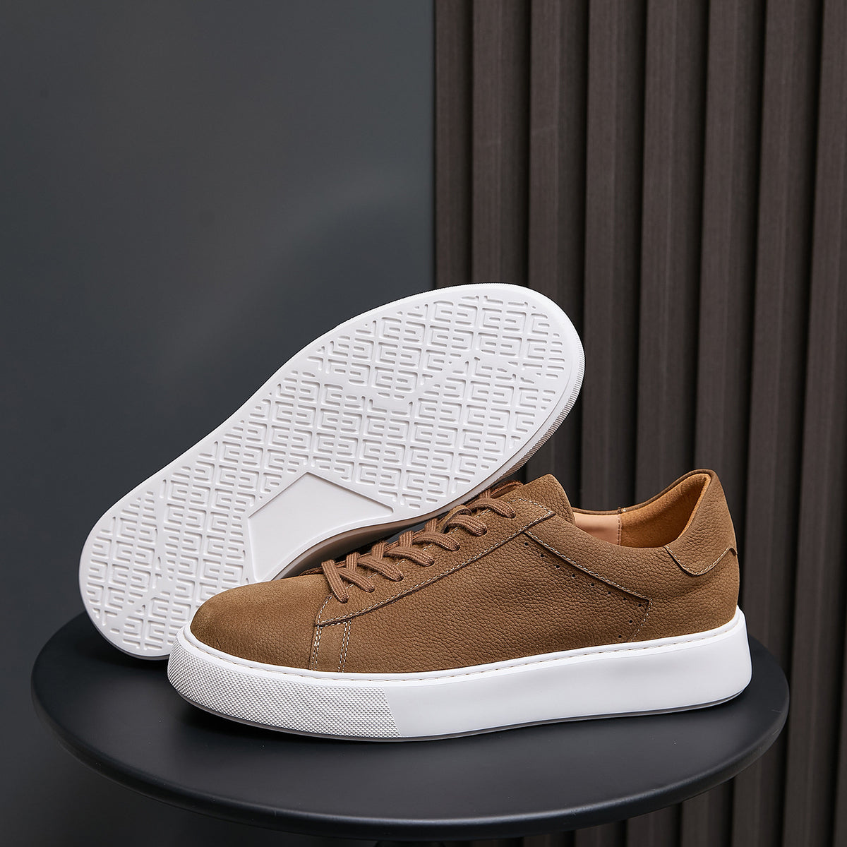Men's brown leather sneakers showing textured white outsole and side panels