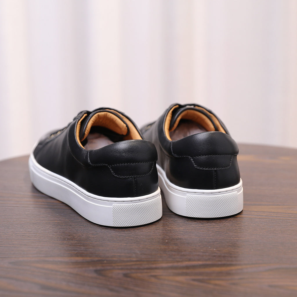 Men's black leather sneakers rear view, heel tab and white rubber sole