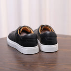 Men's black leather sneakers rear view, heel tab and white rubber sole