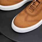 Men's genuine leather sneakers close-up: brown leather with white sidewall and stitched seams