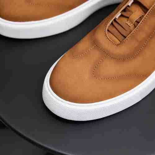 Men's genuine leather sneakers close-up: brown leather with white sidewall and stitched seams