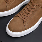 Brown leather sneaker close-up: lace-up front with stitched paneling