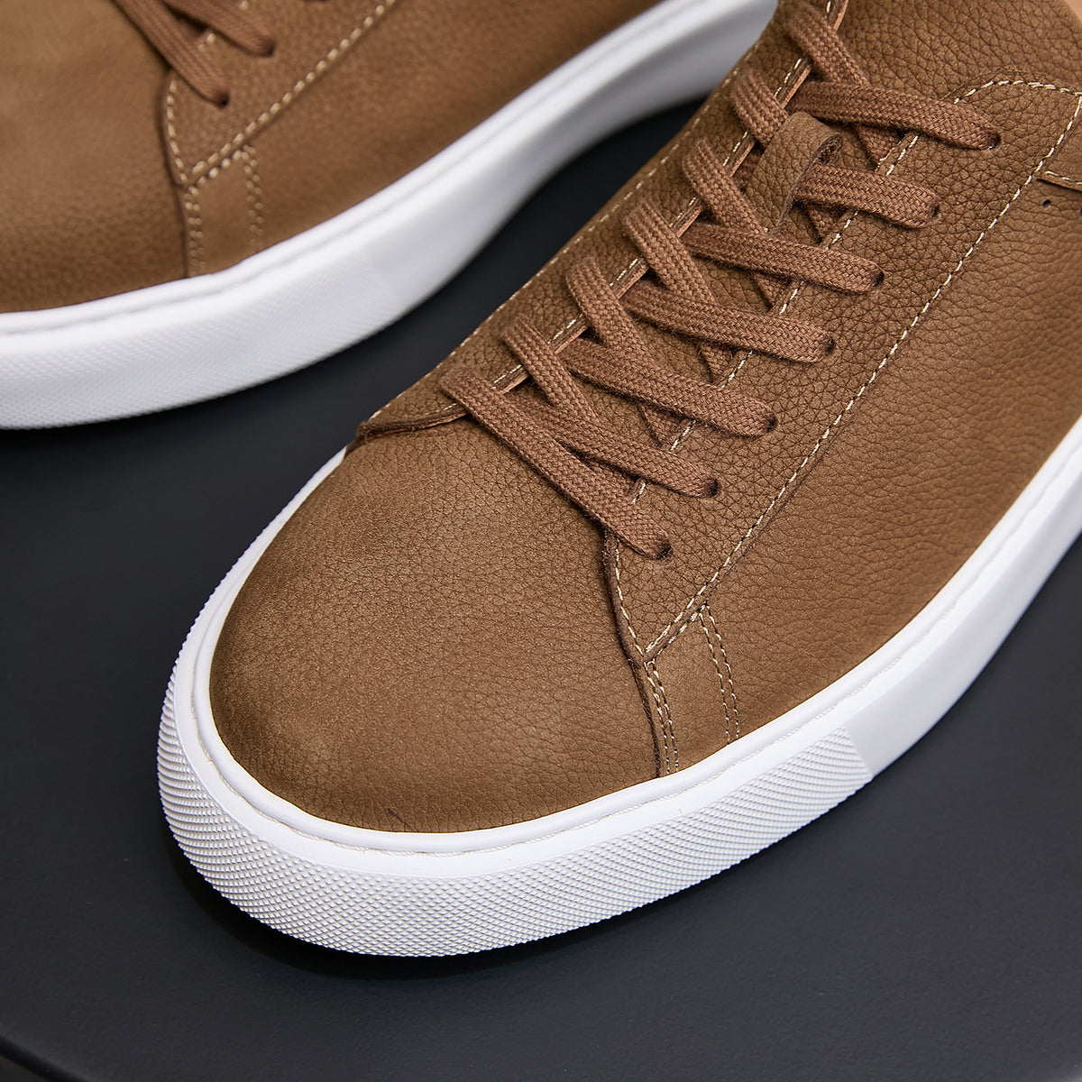 Brown leather sneaker close-up: lace-up front with stitched paneling