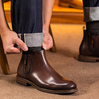 Dark brown leather pointed-toe side-zip dress boot with tan welt; worn with dark pants