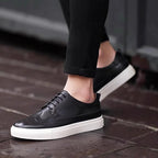 Men's genuine leather sneakers, black lace-up with perforated toe and white sole.