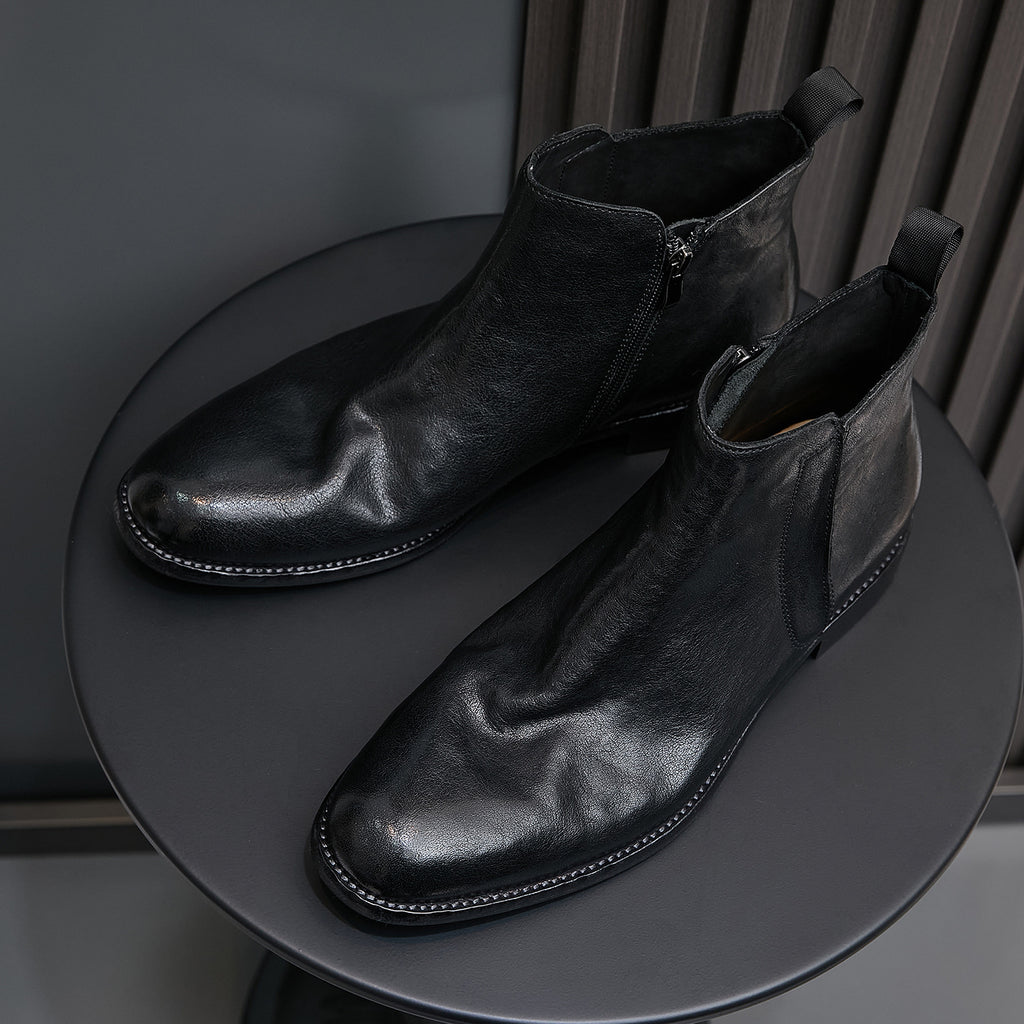 Black leather pointed-toe dress boots with side zipper and low heel