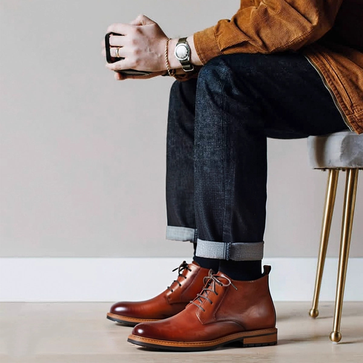 Men's brown leather chukka boots with lace-up closure, plain toe, styled with jeans
