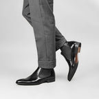 Men's black genuine leather Chelsea dress boots, worn with gray trousers