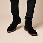 Black Chelsea dress boots with elastic sides and rugged sole under pants