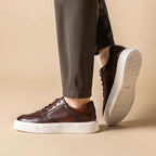 Men's dark brown leather sneakers with lace-up closure and white sidewall sole