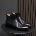 Black pointed-toe Chelsea dress boots with elastic side panels and flat sole