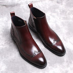 Pair of dark brown leather side-zip formal ankle boots with thick sole and stitched trim