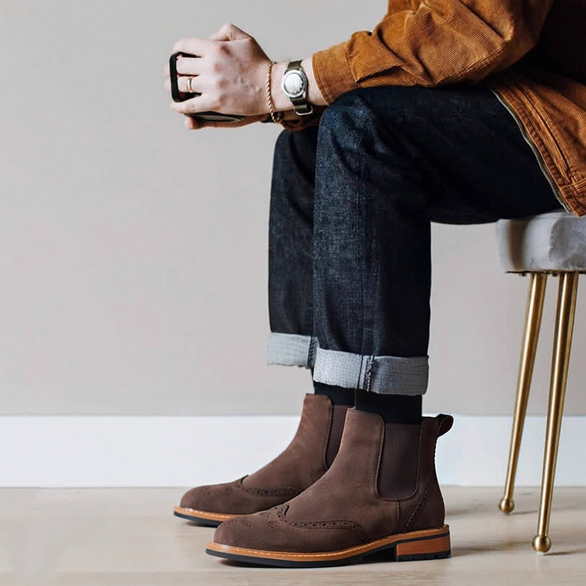 Brown suede pointed-toe Chelsea boots on model with elastic side panels and tan edge