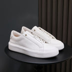 Men's white leather sneakers with lace-up eyelets and textured white sole