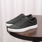 Dark gray suede leather sneakers with lace-up closure and white rubber sole.