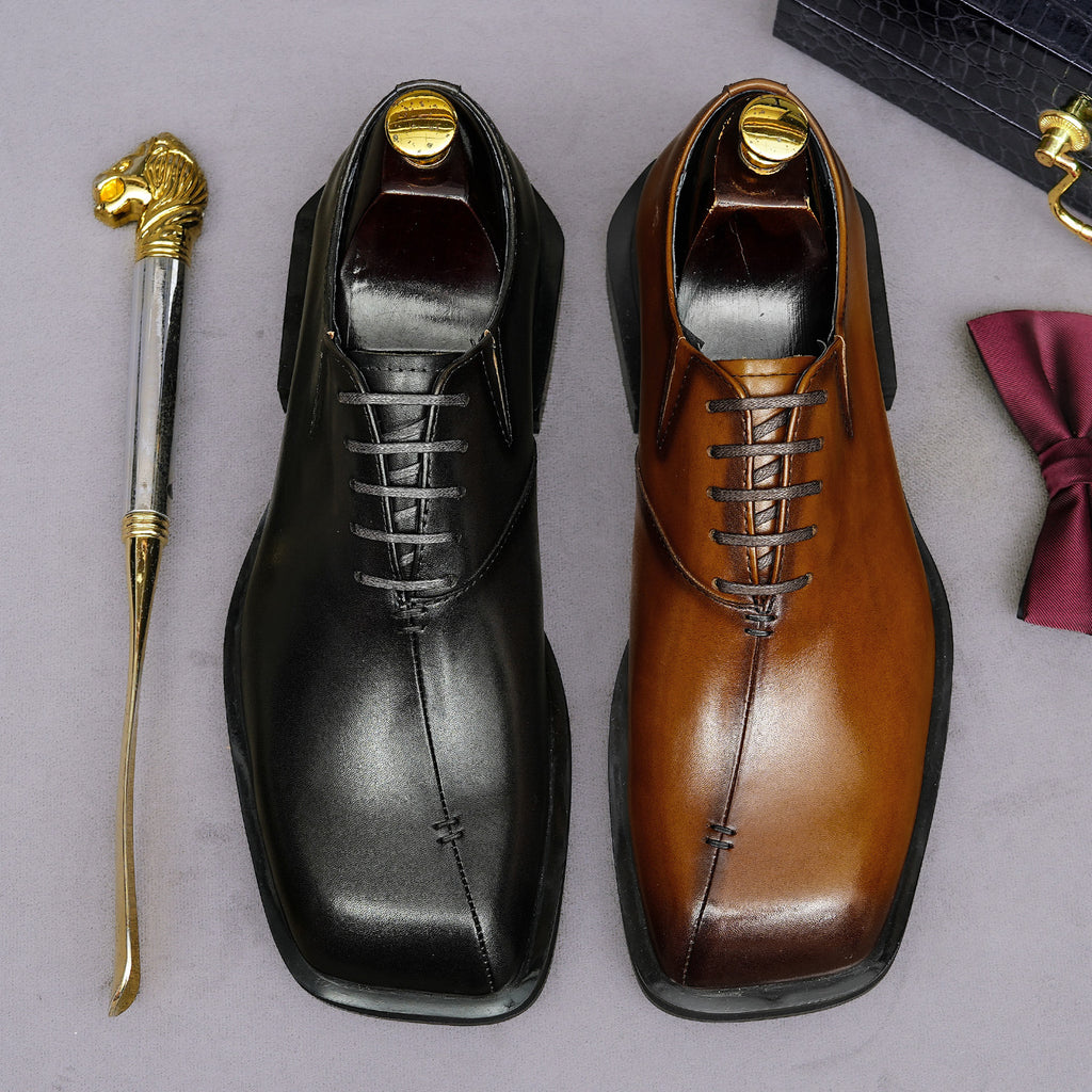 Men's chunky lug-sole wingtip brogue oxfords, black and tan, lace-up pair view.