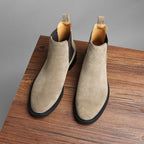 Pair of taupe Chelsea dress boots with side elastic gore and low stacked heel.