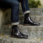 Black leather pointed-toe ankle boots with side zipper and brown sole edge
