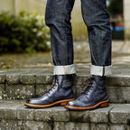 Men's dark leather chukka boots with lace-up front and orange-toned sole trim