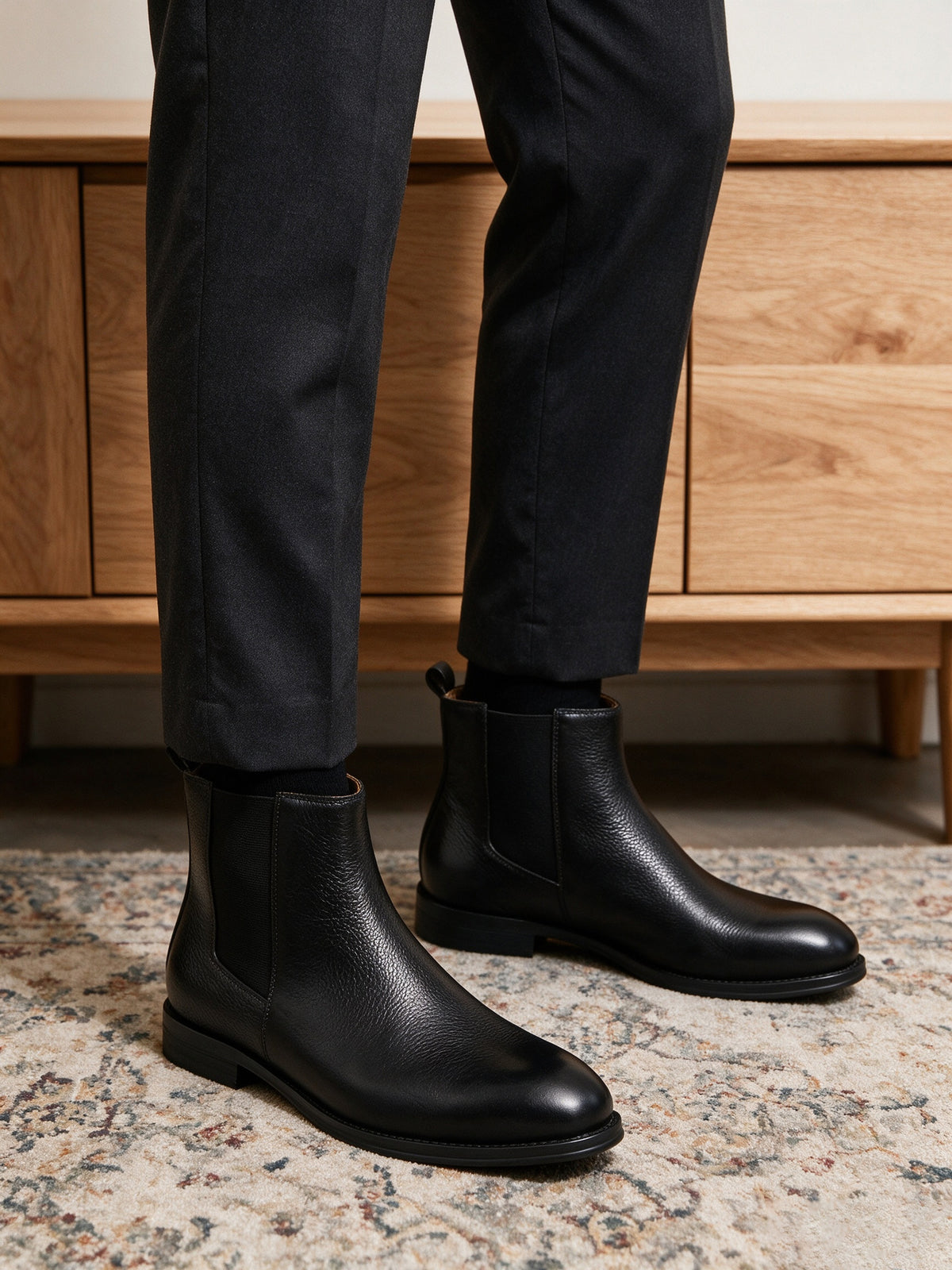Black Chelsea boots with pointed toe, elastic side panels, and low sole