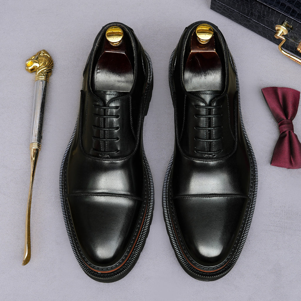 Black lace-up oxford shoes with smooth toe and detailed edge stitching