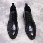Black lace-up dress boots with wingtip perforations and smooth leather finish