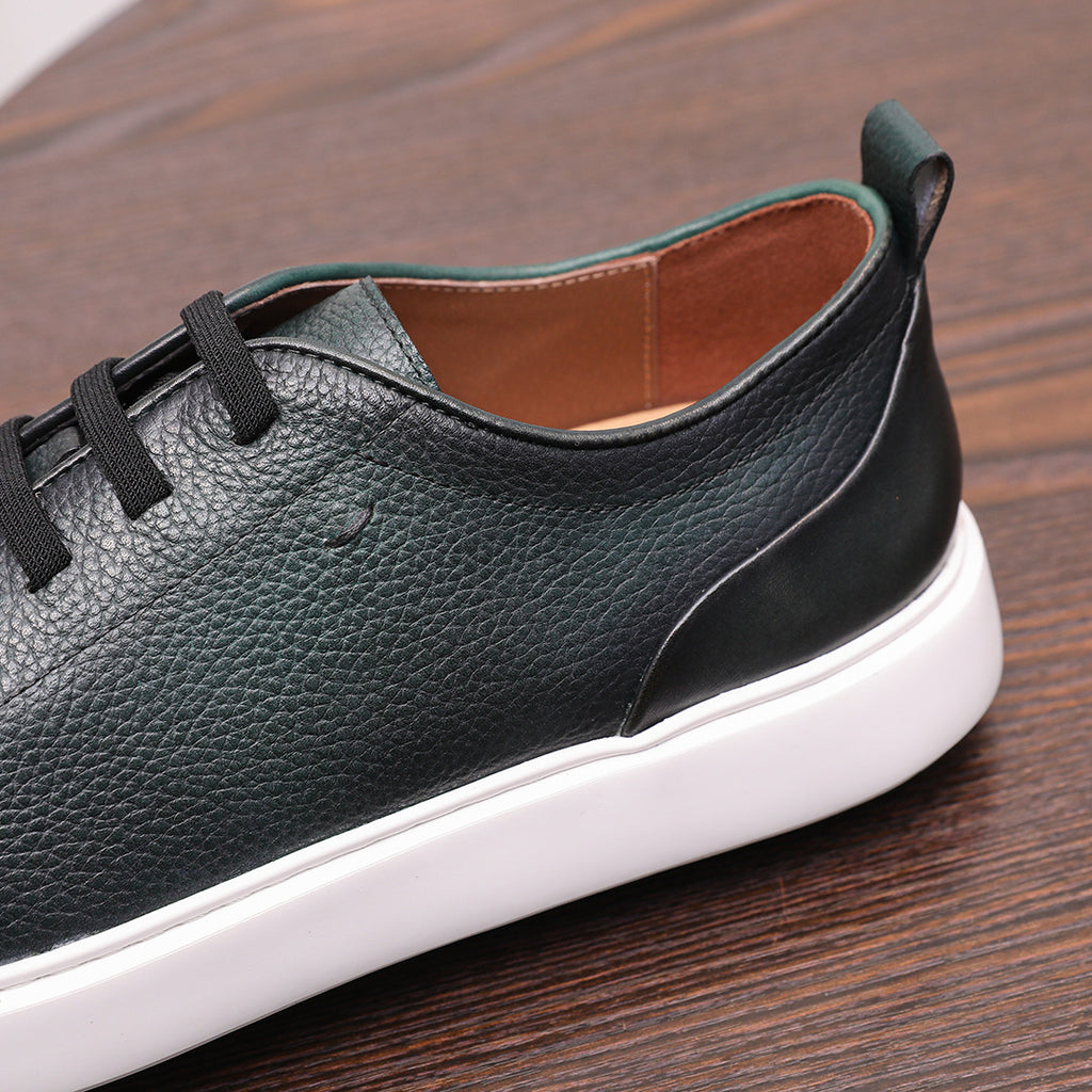 Dark green genuine leather sneaker with lace-up straps and smooth side panel detail.