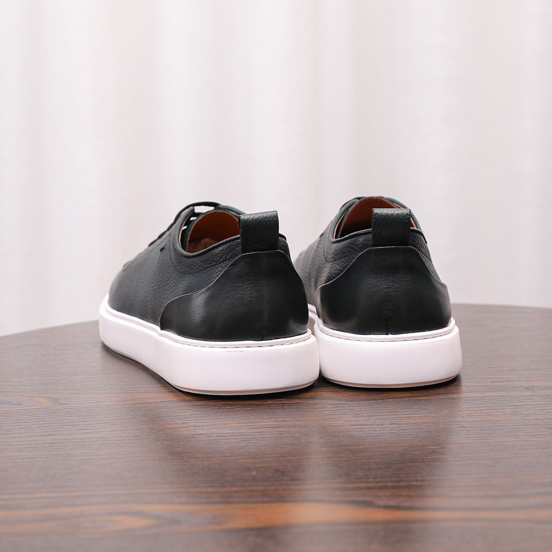 Pair of black genuine leather sneakers, heel and back profile with white rubber soles.