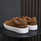 Men's brown leather sneakers from heel view, white rubber sole and tabs