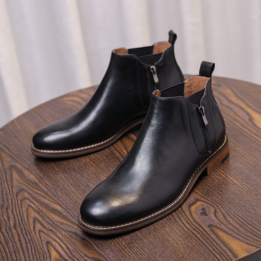 Black leather ankle dress boots with side zipper closure, stitched edge and brown outsole