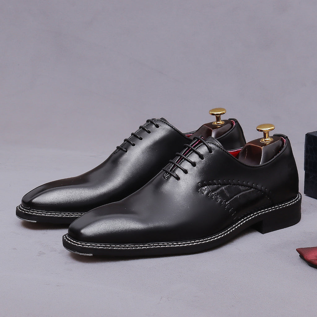 Black wingtip oxford shoes with chunky lug sole and lace-up design