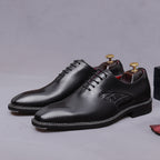Black wingtip oxford shoes with chunky lug sole and lace-up design