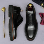 Black oxford shoes with lace-up upper and thick rubber lug sole