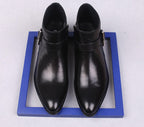 Pair of men's black leather dress boots with side zippers and thick soles.