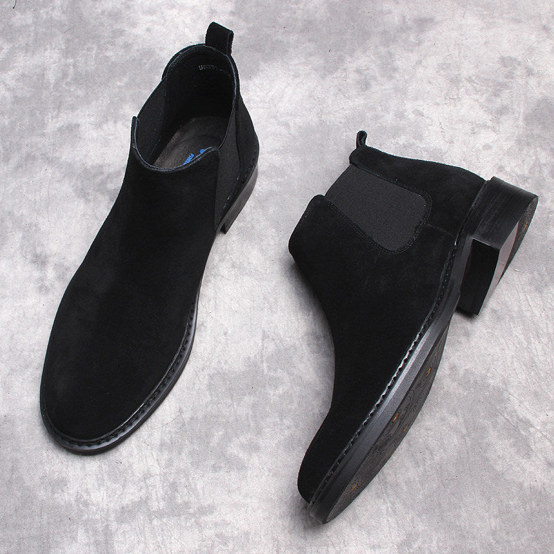 Men's black Chelsea dress boots, angled pair showing low heel and stitched trim