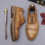 Tan lace-up oxford shoes with brogue/wingtip stitching and chunky lug sole, angled view.