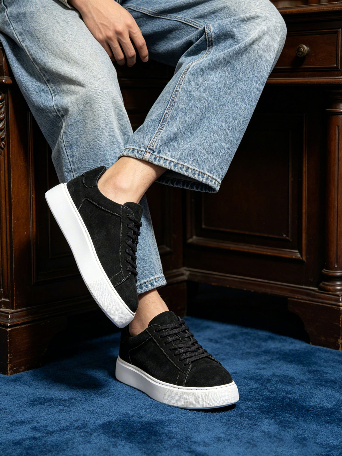 Black leather low-top sneakers with lace-up front and white rubber sole